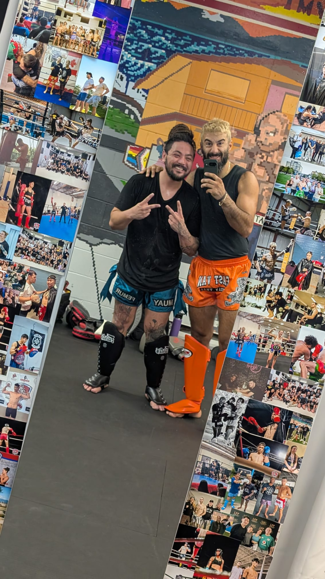 Matt taking a mirror selfie with a training partner in the gym